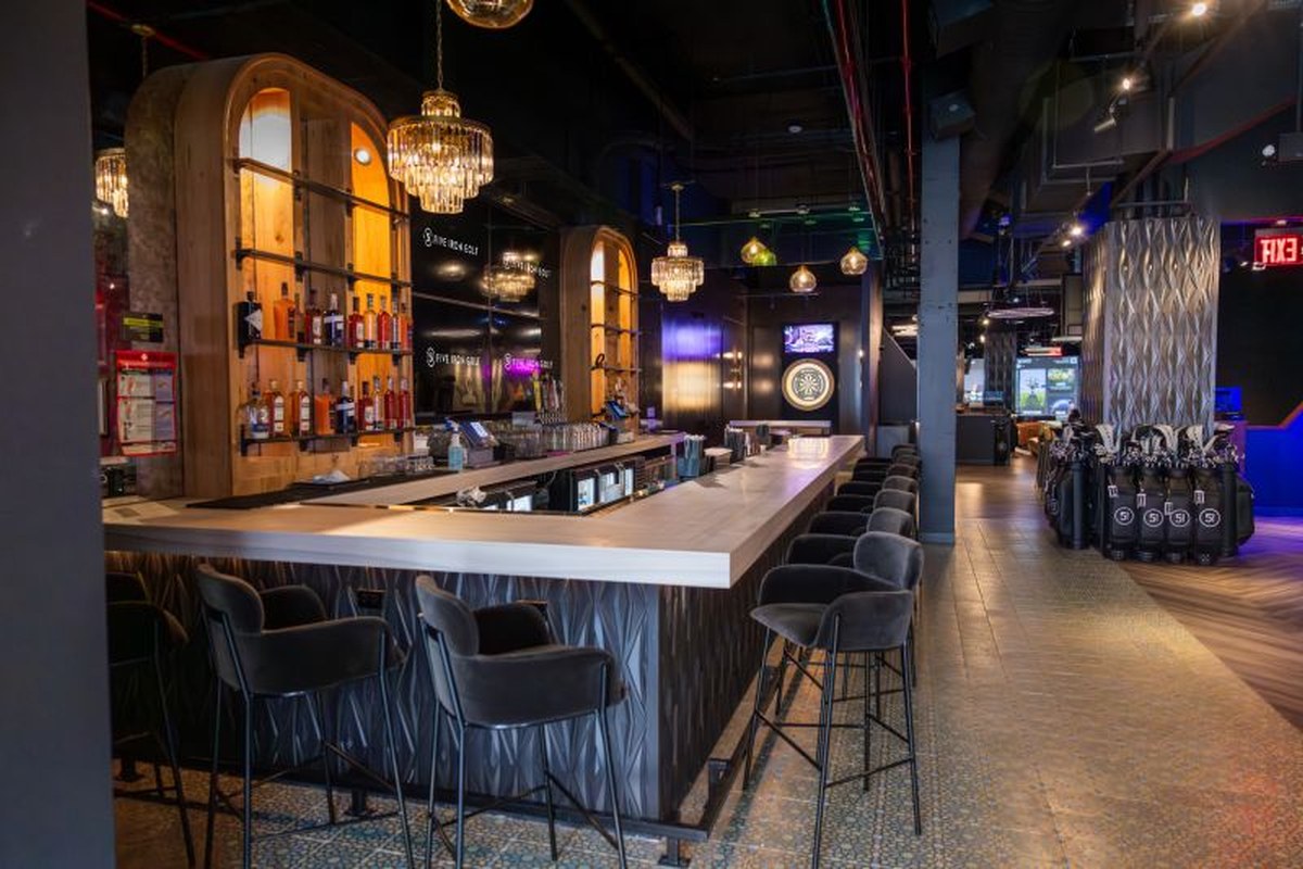 CORCON tenant improvement buildout for Five Iron Golf's Flatiron flagship in New York City — custom bar millwork and arched back-bar display